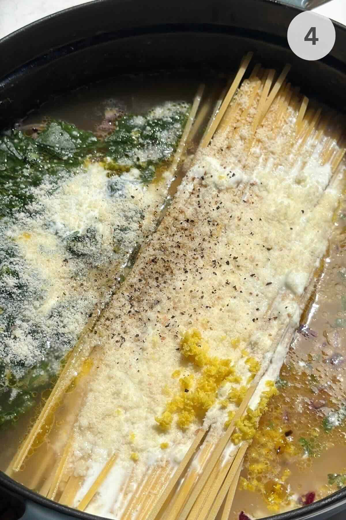 Dry linguine added to lemon garlic sauce with spinach in skillet.