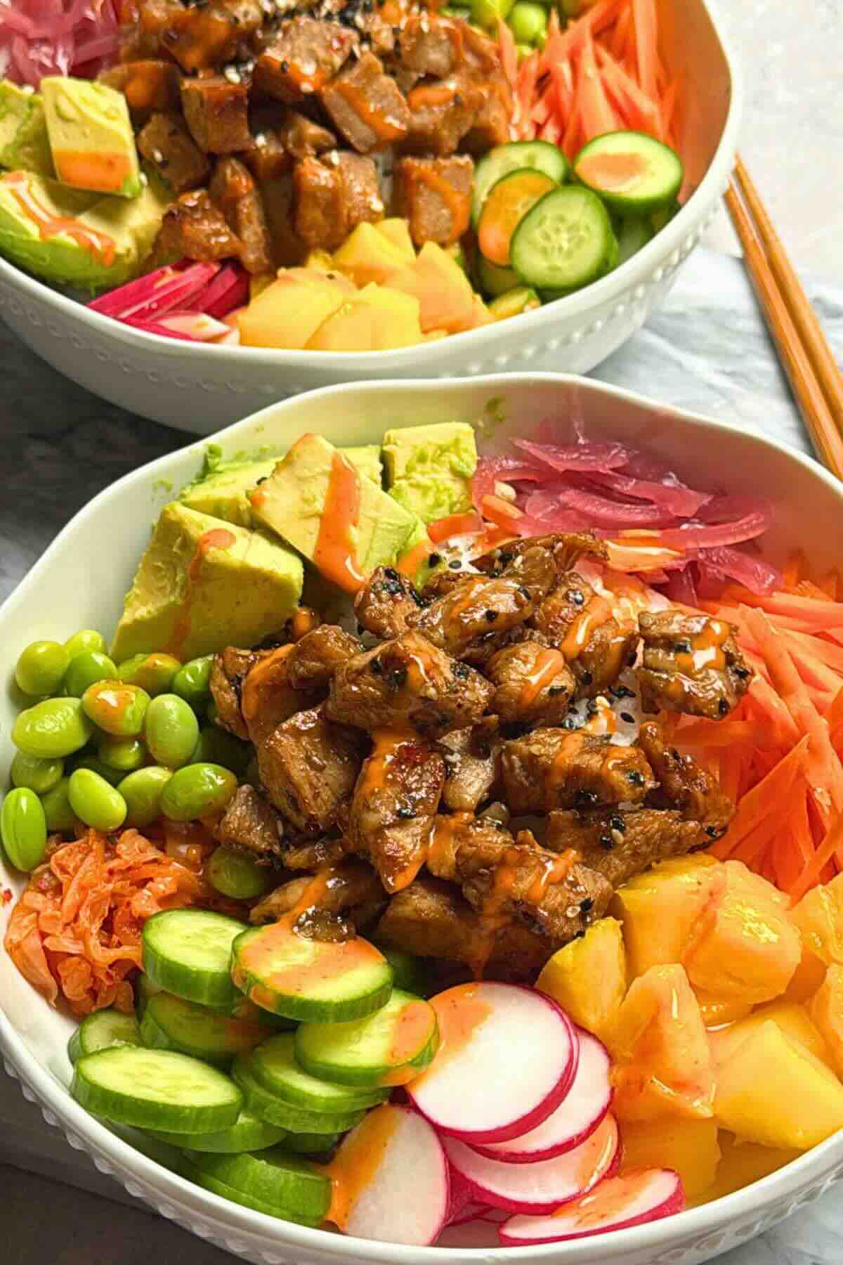 Cooked tuna poke bowl with seared tuna, sushi rice, avocado, and mango in a bowl.