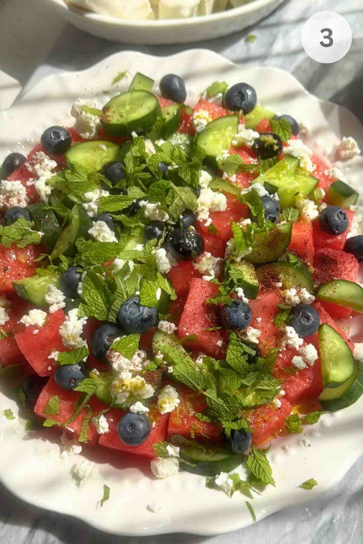 Watermelon cucumber feta salad ingredients added to a large serving bowl.