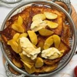 Golden brioche French toast topped with maple caramelized apples and a spoonful of whipped cream.